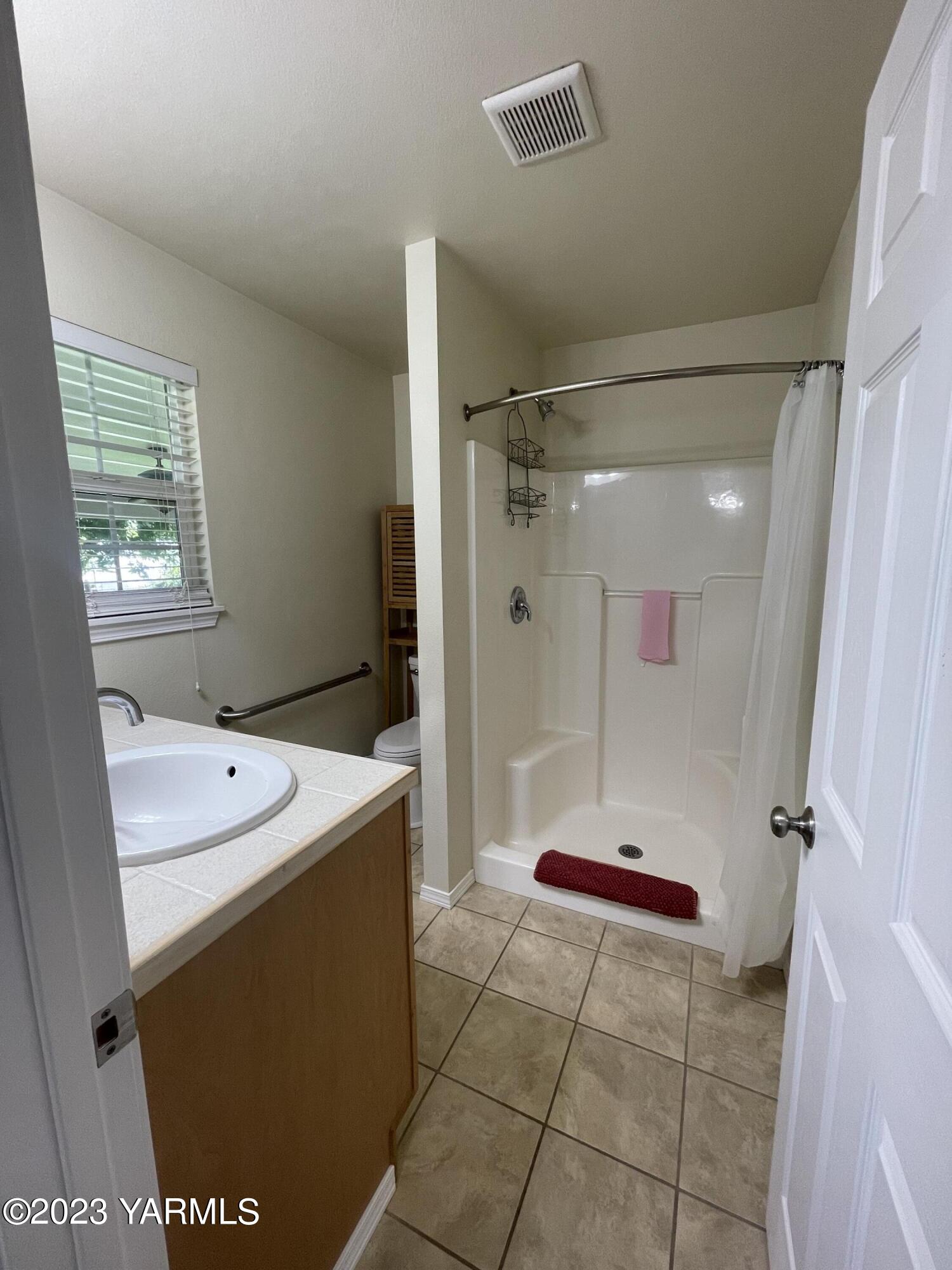 707 Larson Street Grandview, WA 98930 - Photo 9 of 16 a bathroom with a shower a sink and a mirror