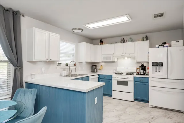 a kitchen with a white stove top oven sink and white cabinets