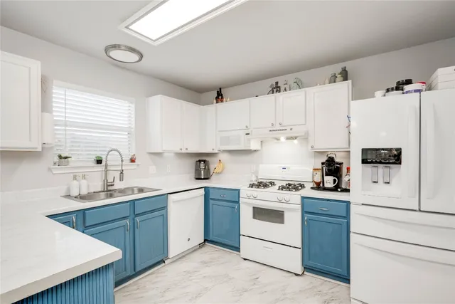 a kitchen with cabinets appliances and wooden floor