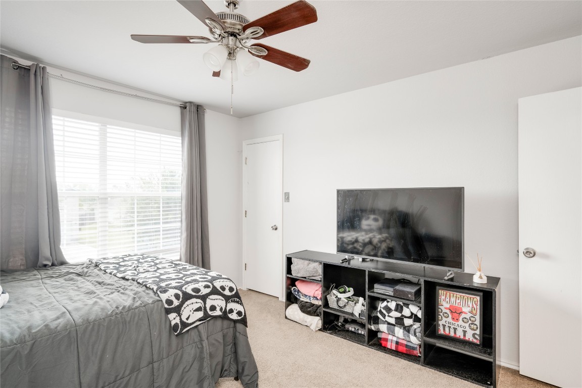 148 Buttercup Way Kyle, TX 78640 - Photo 23 of 40 a bedroom with bed and a flat screen tv