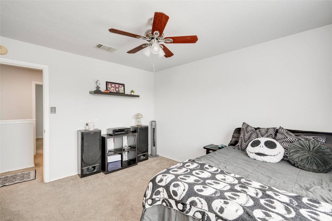 148 Buttercup Way Kyle, TX 78640 - Photo 24 of 40 a bedroom with a bed and a chandelier