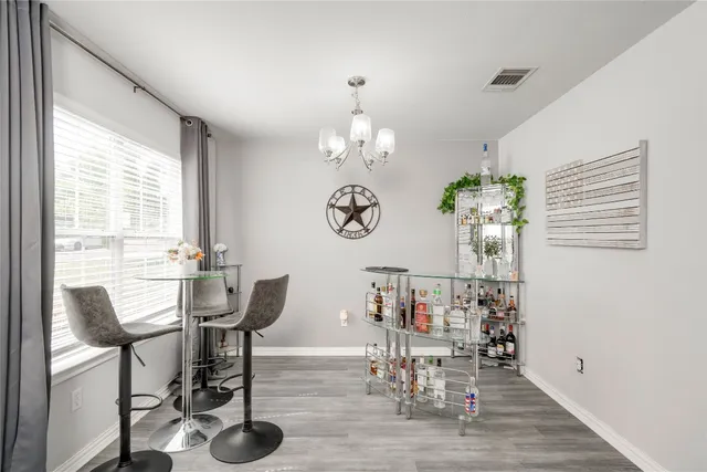 a view of a dining room with furniture a chandelier and wooden floor