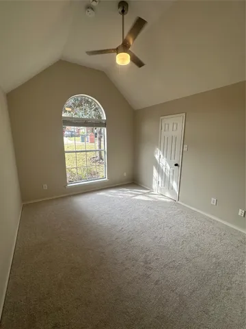an empty room with a window and a ceiling fan