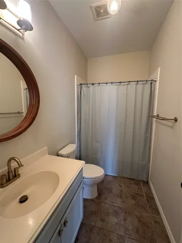 a bathroom with a sink a toilet and shower curtain