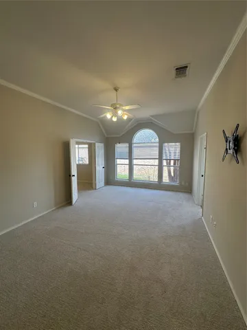 a view of empty room with windows and ceiling fan