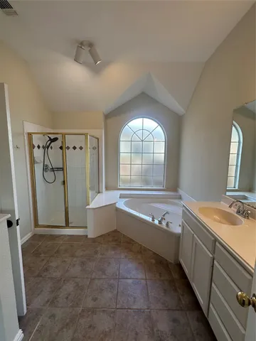 a spacious bathroom with a tub sink and mirror