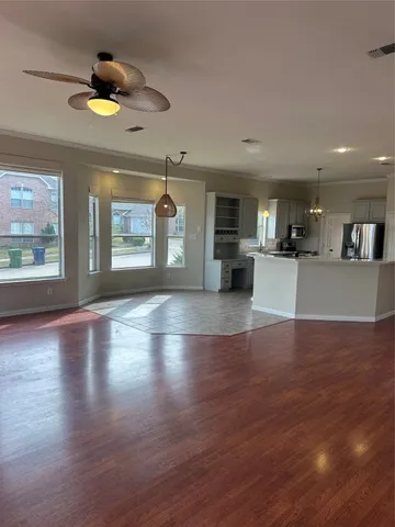 a view of a kitchen with granite countertop a stove top oven a sink with wooden floors