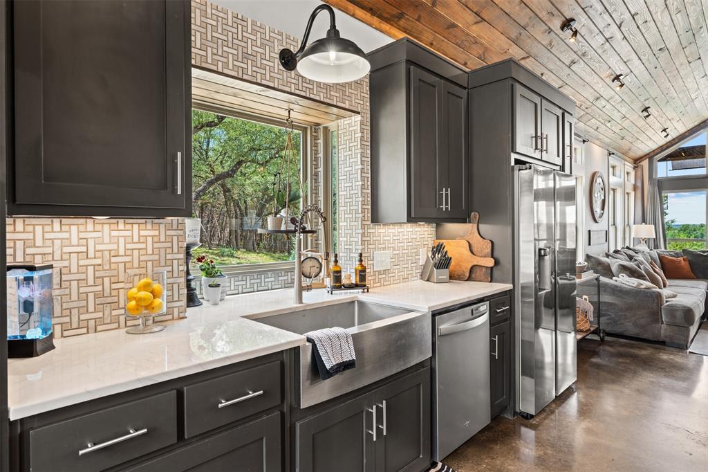 124 Bluffview Circle China Spring, TX 76633 - Photo 9 of 40 Modern kitchen featuring dark cabinetry, stainless steel appliances, a farmhouse sink, light countertops, and a patterned tile backsplash