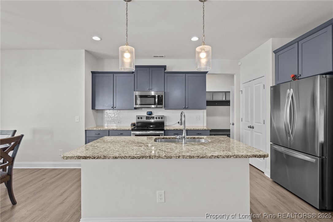 212 Winnsboro Road Raeford, NC 28376 - Photo 12 of 50 a kitchen with stainless steel appliances granite countertop a sink a refrigerator a stove a kitchen island with chairs and refrigerator