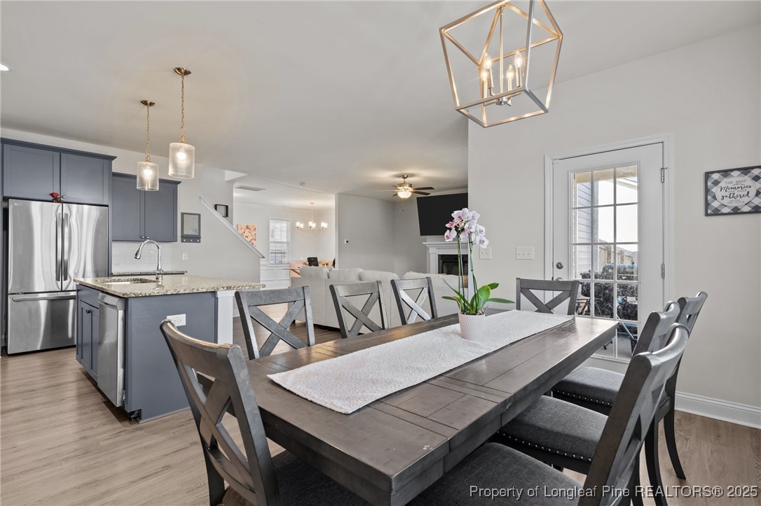 212 Winnsboro Road Raeford, NC 28376 - Photo 17 of 50 a dining room with wooden floor a chandelier a wooden table and chairs