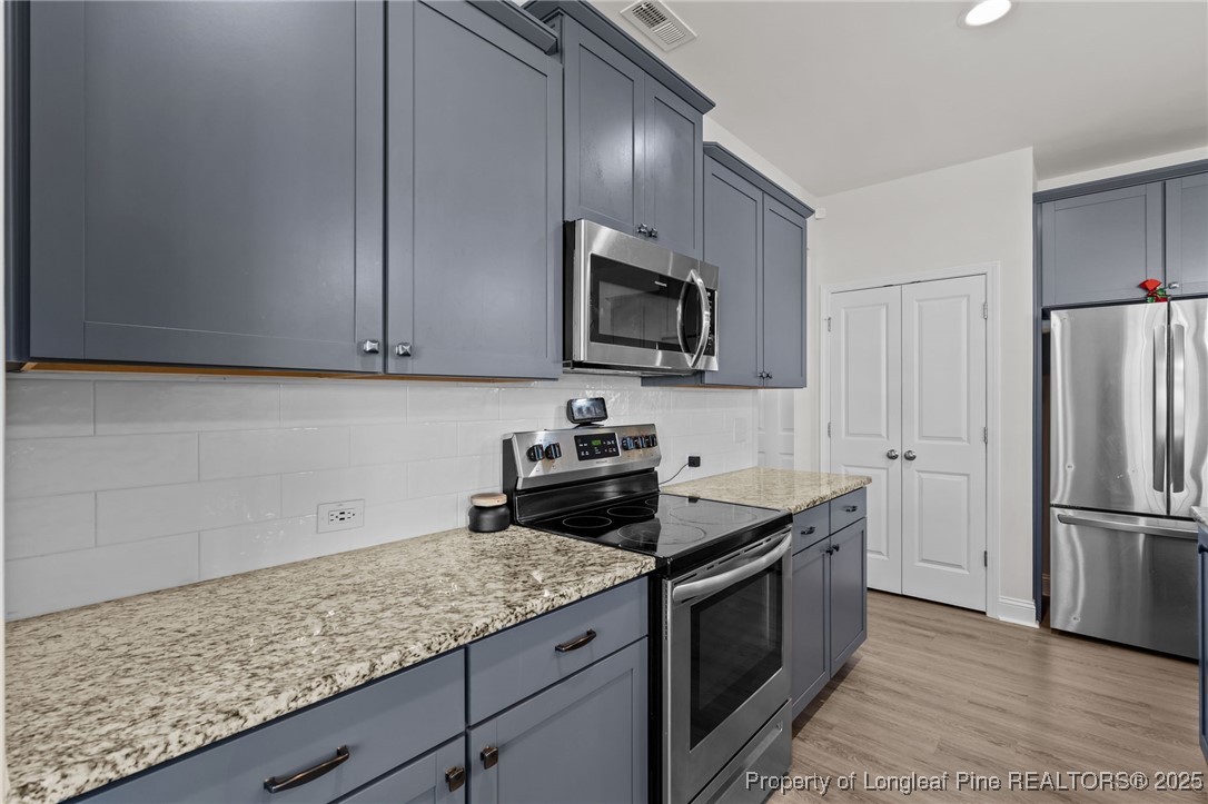212 Winnsboro Road Raeford, NC 28376 - Photo 19 of 50 a kitchen with granite countertop stainless steel appliances and wooden cabinets