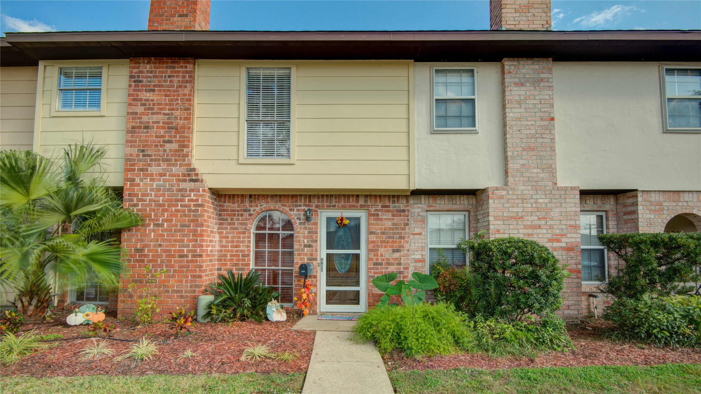 a front view of a house with plants