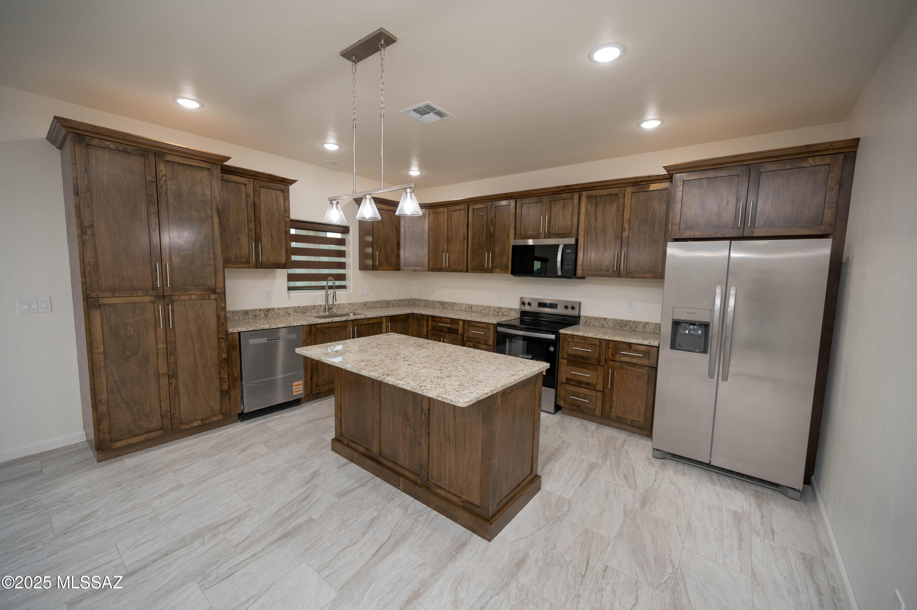497 Calle Cipres Rio Rico, AZ 85648 - Photo 22 of 50 a kitchen with stainless steel appliances granite countertop a refrigerator a sink a stove a microwave and island