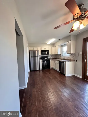 a kitchen with stainless steel appliances granite countertop a stove and wooden floors