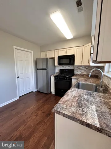 a kitchen with a sink a microwave a refrigerator and cabinets