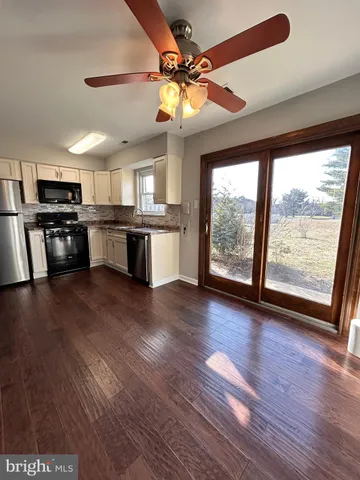 a large kitchen with cabinets wooden floor and stainless steel appliances