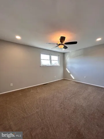 a view of a big room with windows and chandelier fan