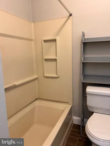 a bathroom with a tub and toilet
