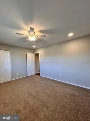 a view of an empty room with a ceiling fan