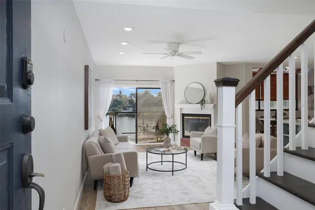 a living room with furniture a fireplace and a floor to ceiling window
