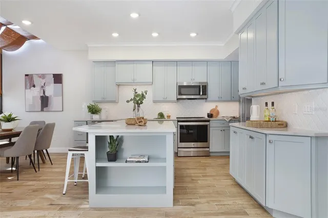 a kitchen with a sink white cabinets and stainless steel appliances