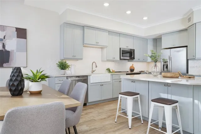 a kitchen with white cabinets and chairs