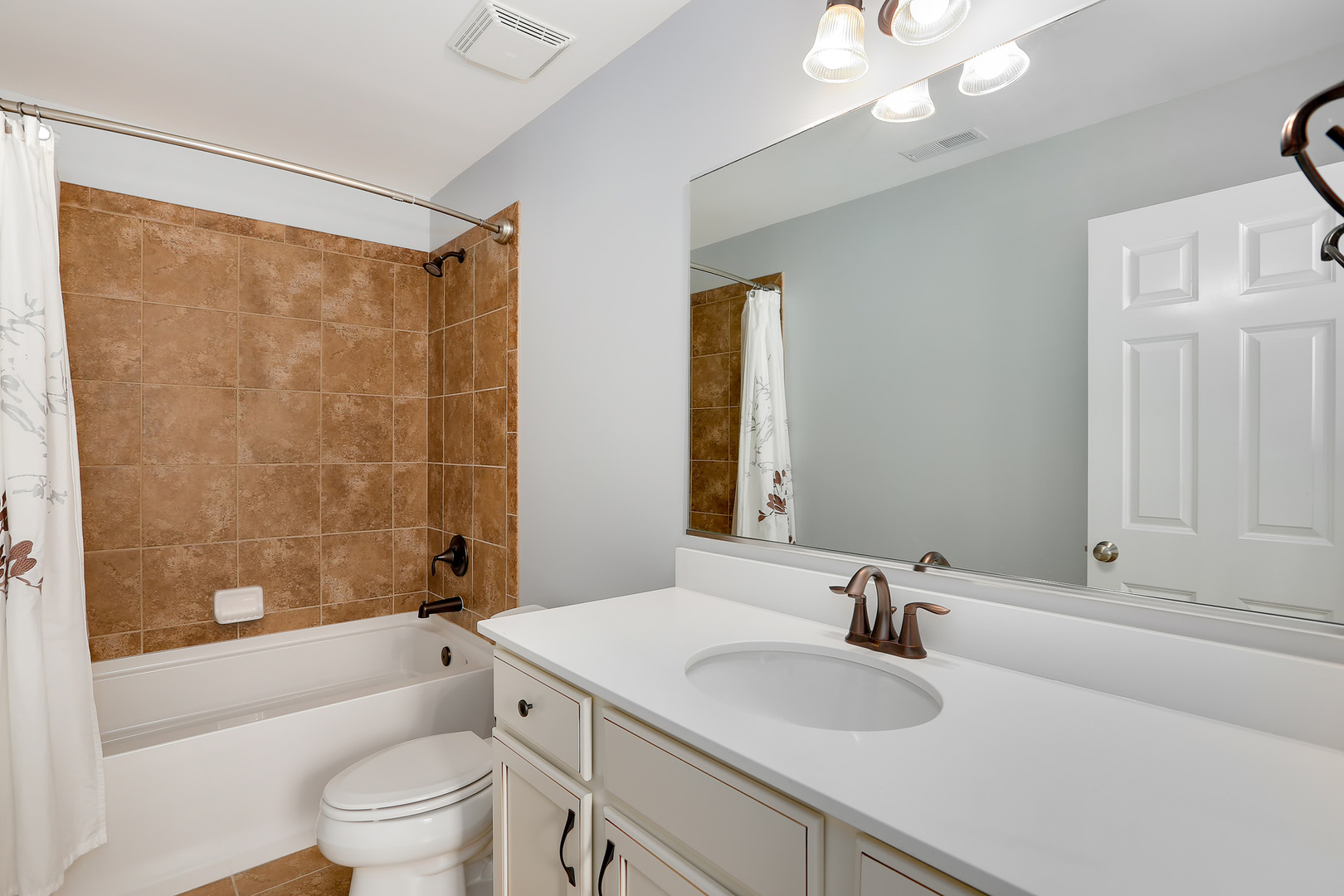 2827 Church Road Aurora, IL 60502 - Photo 21 of 30 a bathroom with a sink a toilet a mirror a bathtub and shower