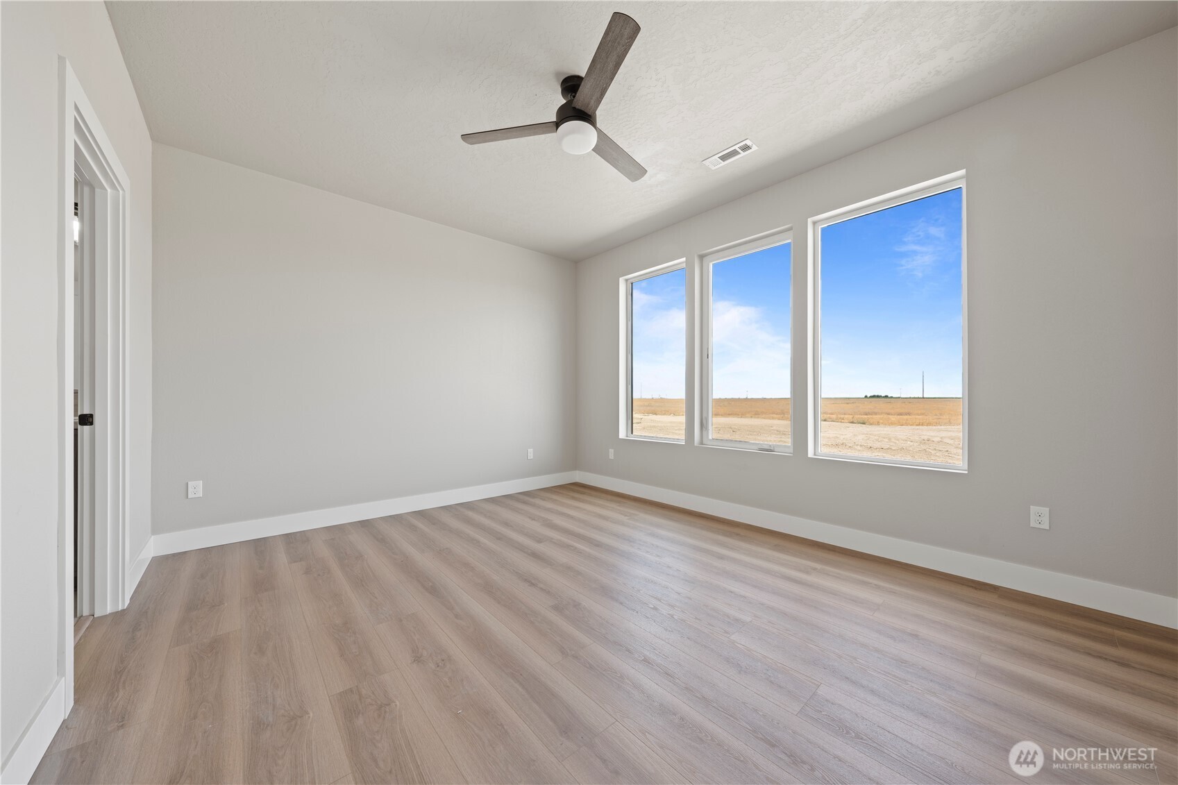 1121 E Mount Othello, WA 99344 - Photo 5 of 33 a view of empty room with wooden floor and fan