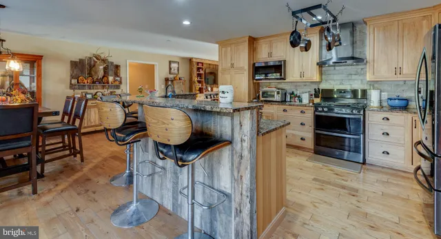 a kitchen with stainless steel appliances granite countertop a stove refrigerator and cabinets