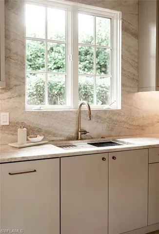 a kitchen with sink a window and cabinets
