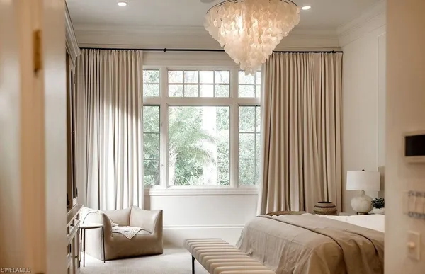 a bedroom with a bed and a chandelier