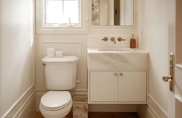 a white toilet sitting next to a bathroom sink