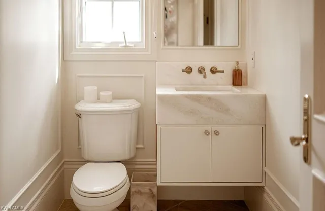 a white toilet sitting next to a bathroom sink