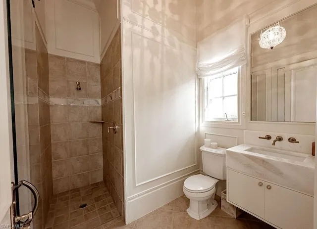 a bathroom with a toilet sink vanity and shower