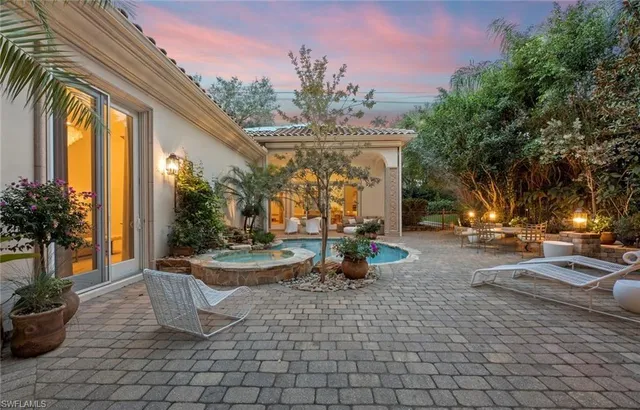 a view of a patio with table and chairs potted plants and palm trees