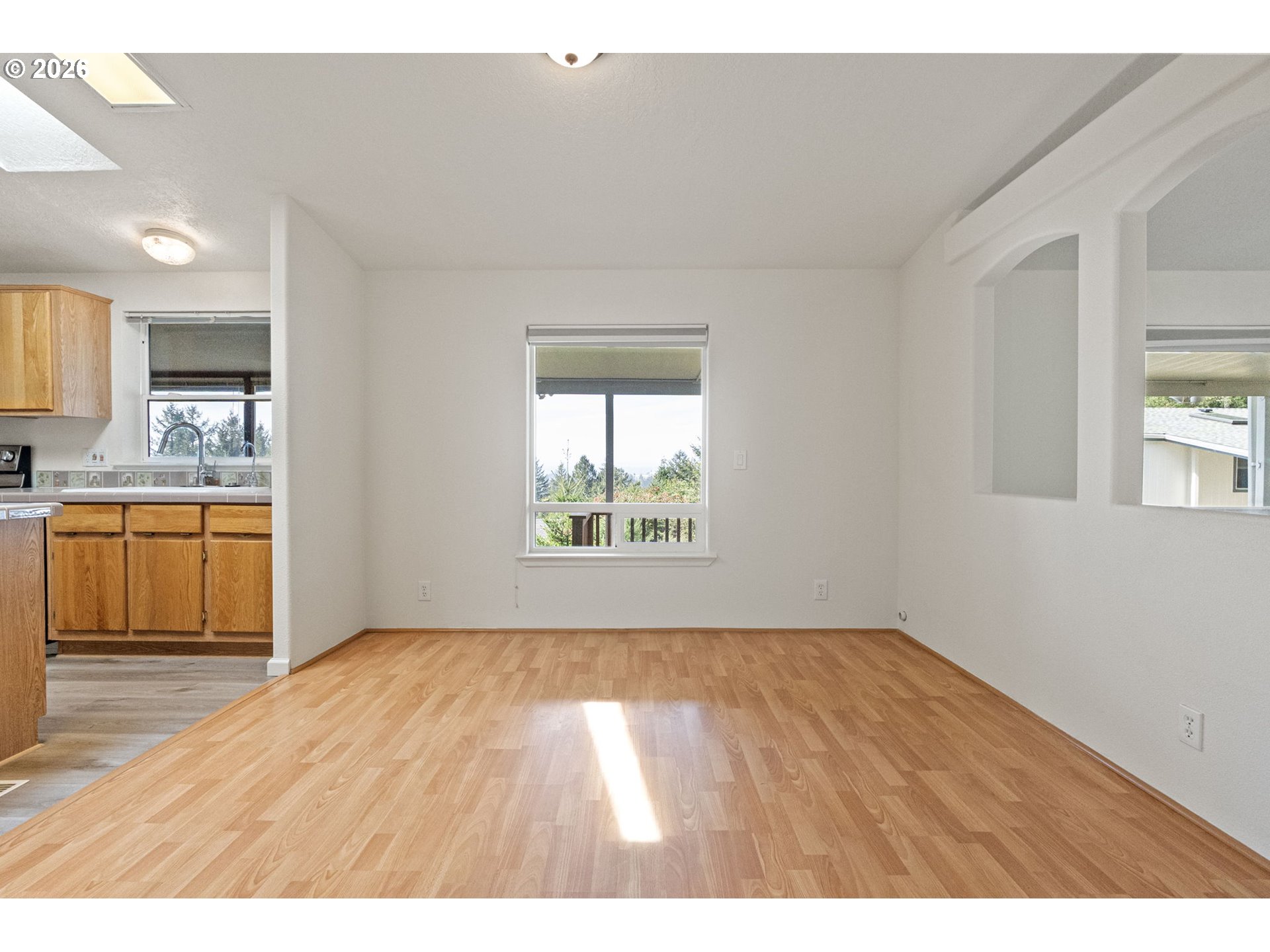 98041 Hallway Road, Unit 41 Brookings, OR 97415 - Photo 6 of 48 a view of a kitchen and an empty room with wooden floor and a window