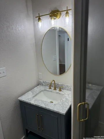 a bathroom with a granite countertop sink and a mirror