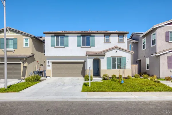 a front view of a house with a garden and plants