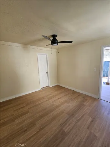 a view of a room with wooden floor and a ceiling fan