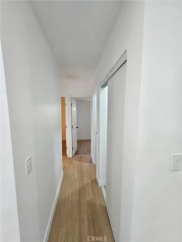 a view of a room with wooden floor and a bathroom