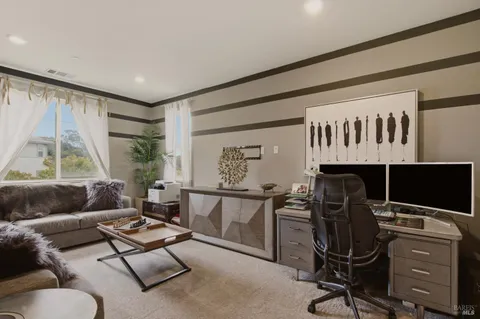 a living room with furniture gym equipment and a large window