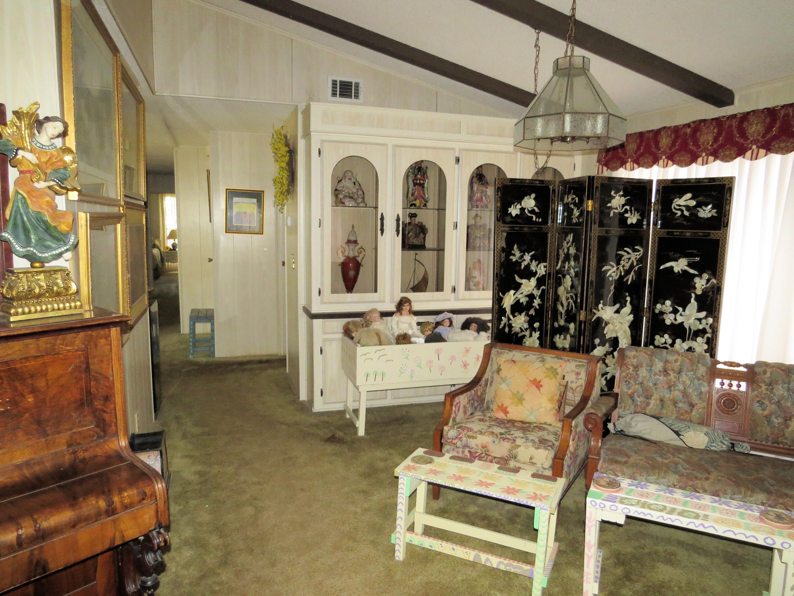 34980 Serenade Thousand Palms, CA 92276 - Photo 10 of 37 a living room with fireplace furniture and a chandelier