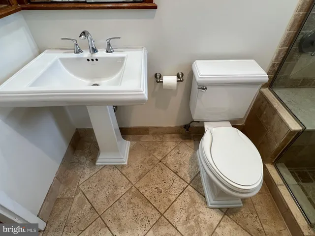 a bathroom with a sink toilet and a mirror