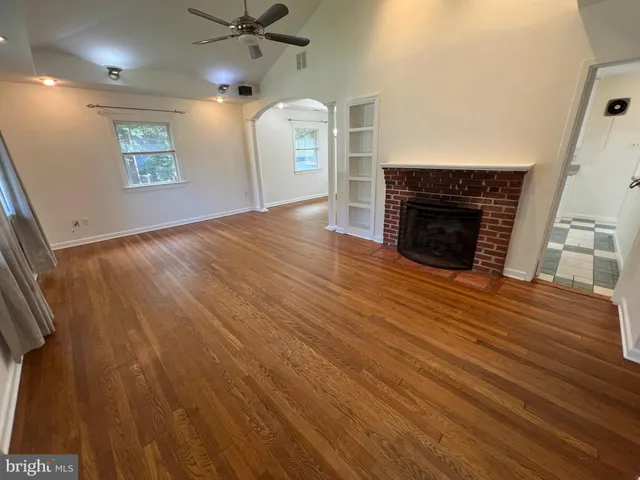 wooden floor fireplace and windows in an empty room