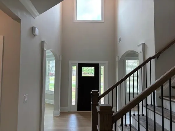 a view of staircase with lots of frames on wall and wooden floor