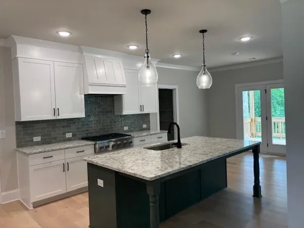 a kitchen with granite countertop kitchen island a sink appliances and a counter top space
