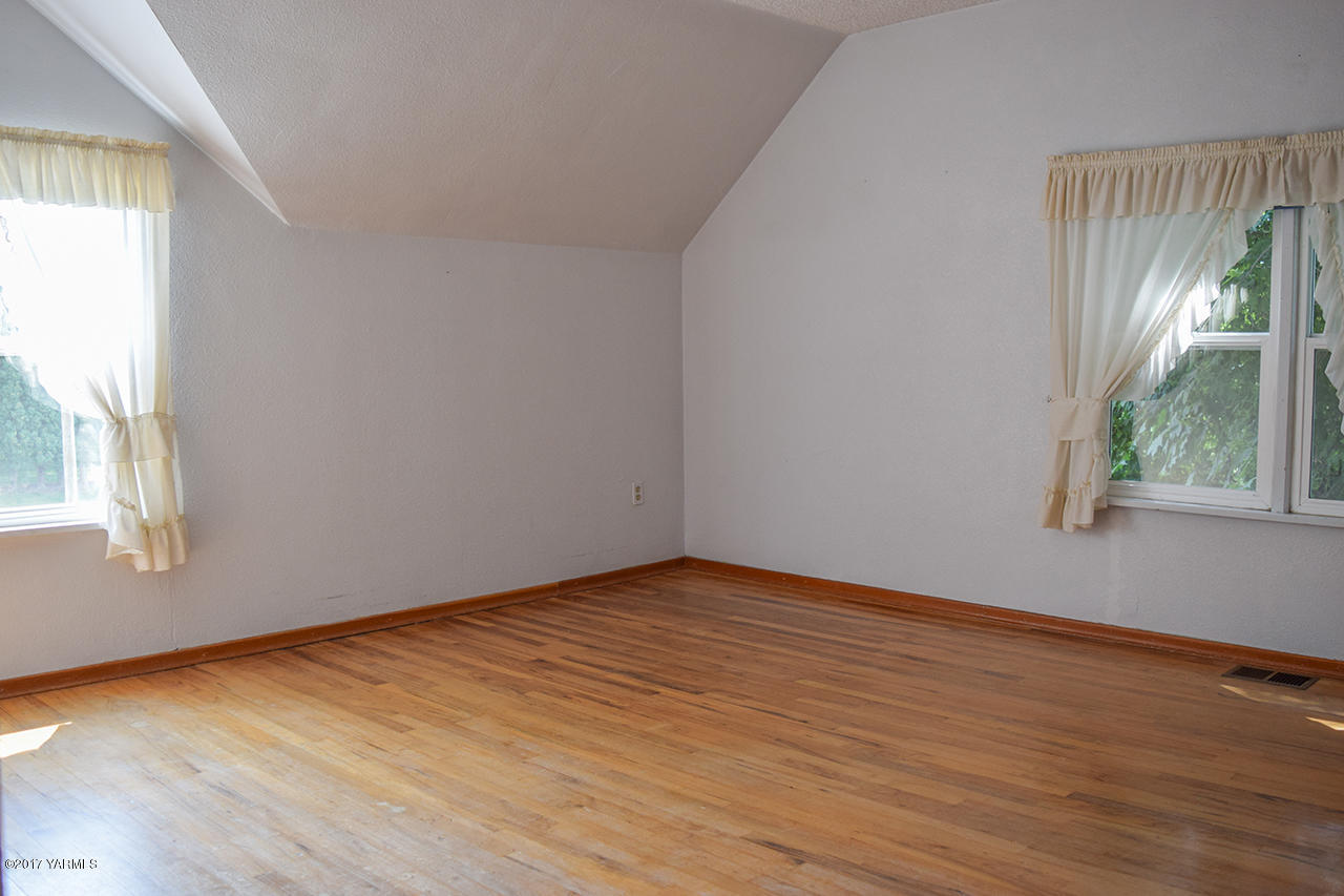 1001 Division Road Zillah, WA 98953 - Photo 16 of 24 an empty room with wooden floor and windows