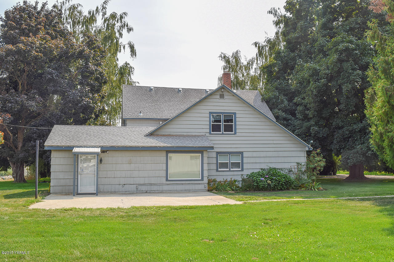 1001 Division Road Zillah, WA 98953 - Photo 24 of 24 a front view of a house with a garden and trees
