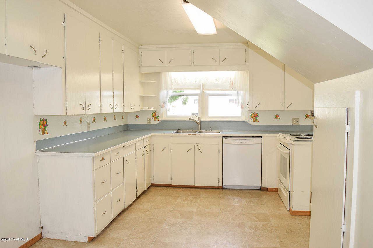 1001 Division Road Zillah, WA 98953 - Photo 5 of 24 a kitchen with granite countertop white cabinets sink and white appliances