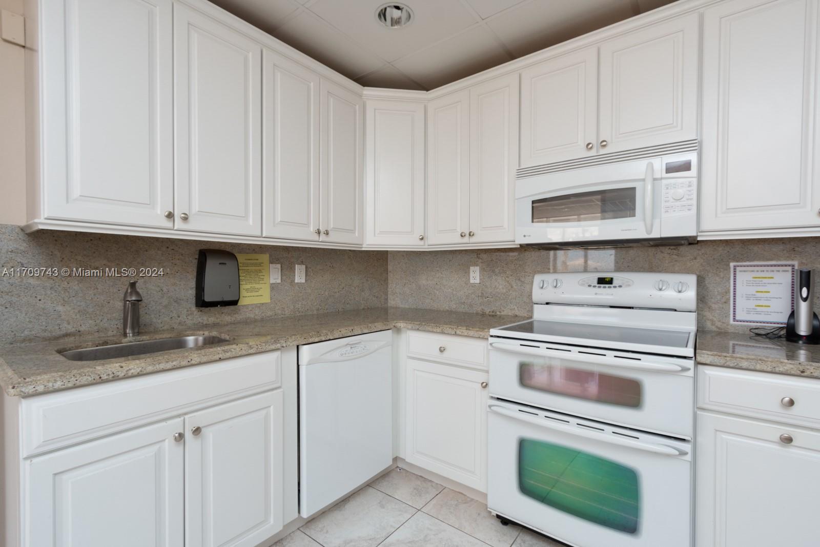 1200 South Ocean Boulevard, Unit PHF Boca Raton, FL 33432 - Photo 57 of 65 a kitchen with granite countertop white cabinets and white stainless steel appliances